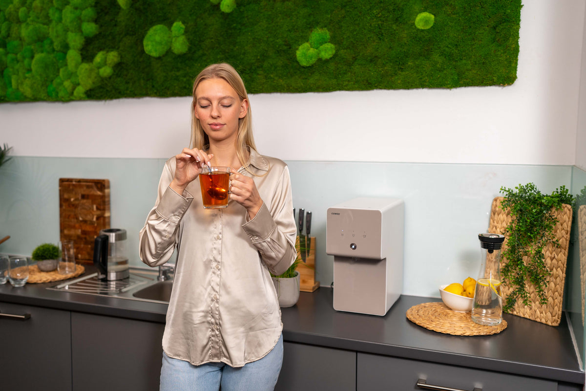 Woman drinking filtered water from Coway system
