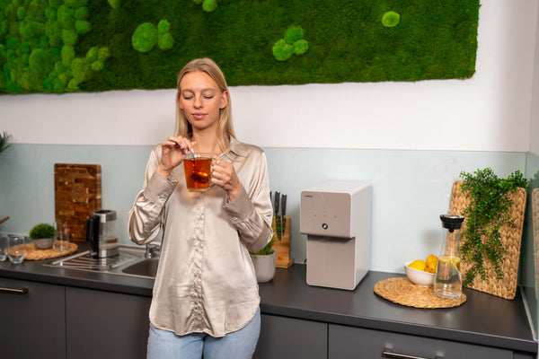 Woman drinking filtered water from Coway system