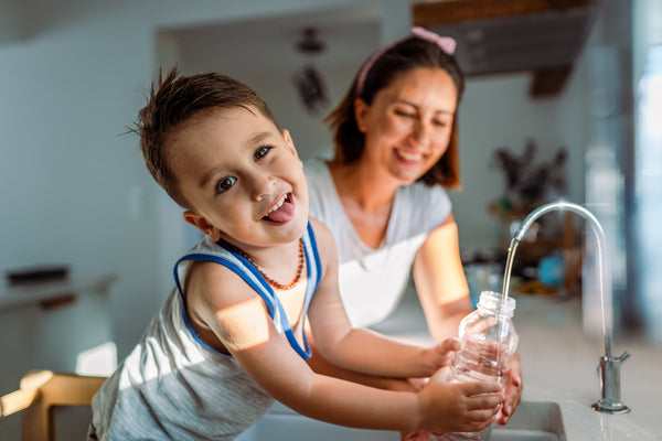 Mother and child using filtered water at home Cyprus